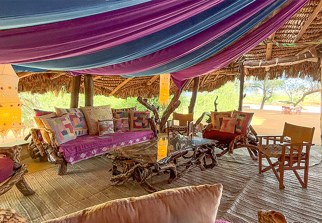 elephant-watch-camp-samburu-lounge-contains-chunky-wooden-framed-seating-with-plenty-of-colourful-cushions-for-guests-to-sit-and-chat Elephant Watch Camp Samburu