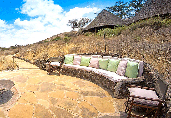 tortilis-camp-amboseli-national -park-fire-pit-has-safari-chairs-and-cushioned-stone-seating-the-perfect-place-for-pre-dinner Tortilis Camp Amboseli National Park | Prices | Facilities & Activities