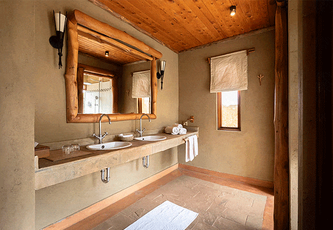 severin-safari-camp-junior-suites-tsavo-west-national-park-features-spacious-bathrooms-include-double-washbasins-and-large-windows-that-let-in-natural-light-enhancing-the-tranquil-ambiance Severin Safari Camp Junior Suites Tsavo West National Park