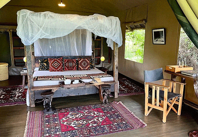 chyulu-club-luxury-safari-lodge-tents-feature-a-four-poster-double-bed-with-mosquito-netting-bedside-tables-and-lighting-and-a-writing-desk Chyulu Club Luxury Safari Lodge